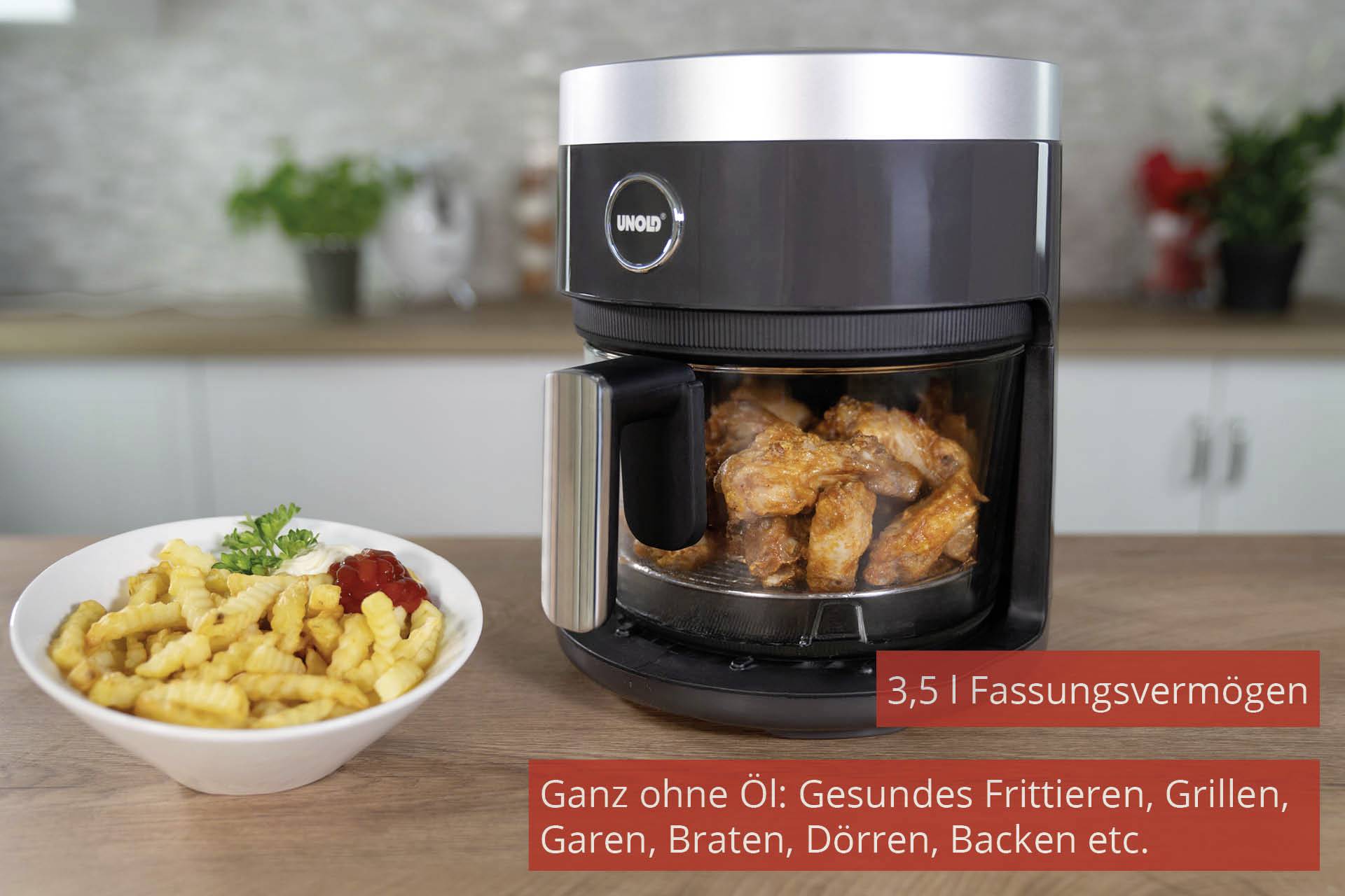 Luftfritteuse mit gebratenem Hähnchen drin, daneben ein Teller Pommes. Text: '3,5 l Fassungsvermögen. Ganz ohne Öl.'
