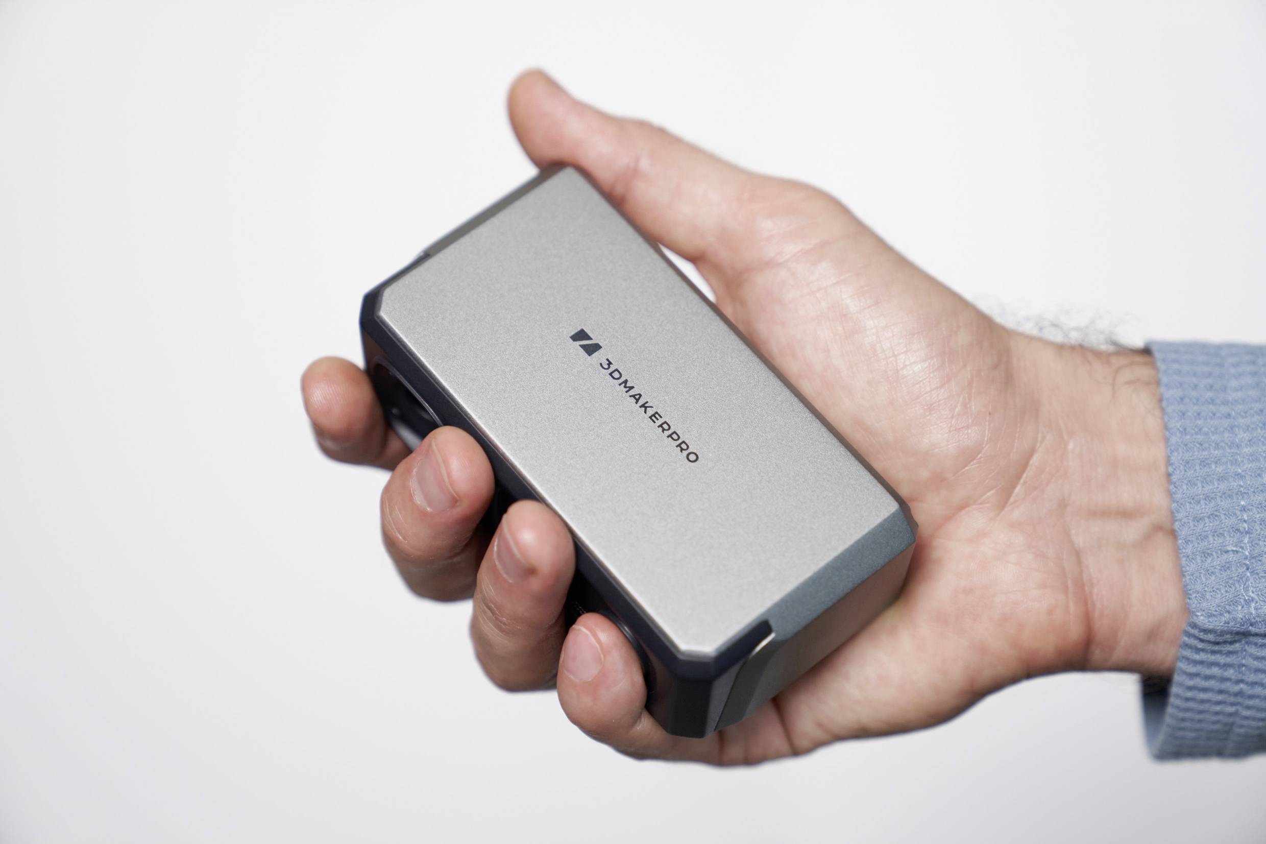 A hand is holding a compact, silver power bank with a '3Dmakepro' logo.