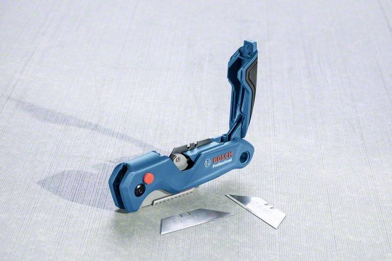 A blue multi-tool with an open blade lies on a grey surface, with two spare blades next to it.