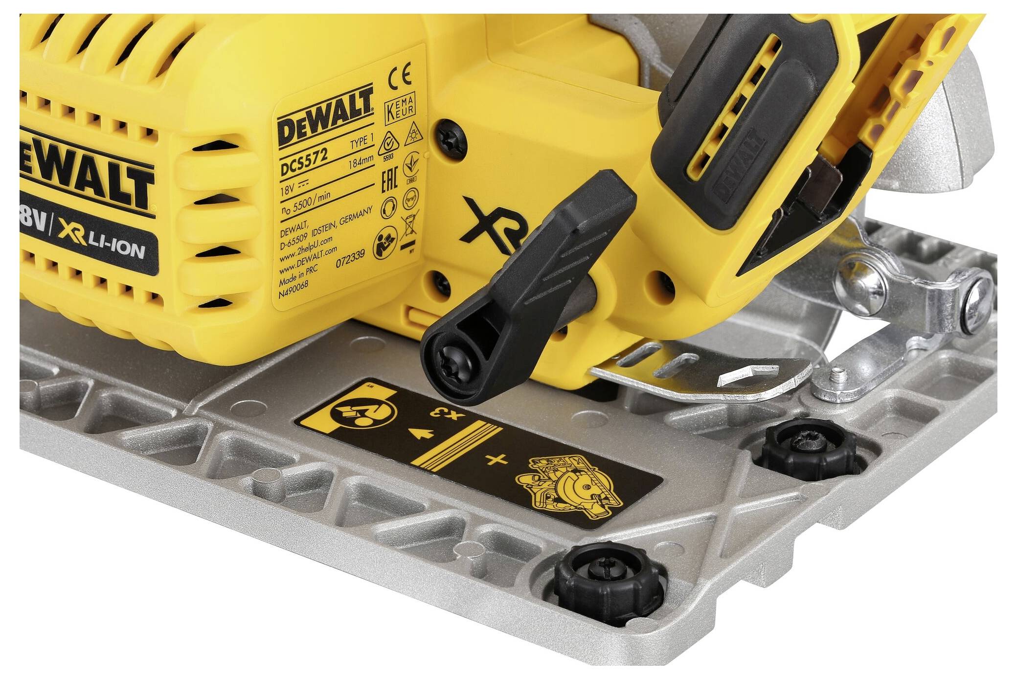 Detailed view of a yellow DeWalt cordless circular saw with operating lever and warning symbols. Screw fastening and metal plate visible.