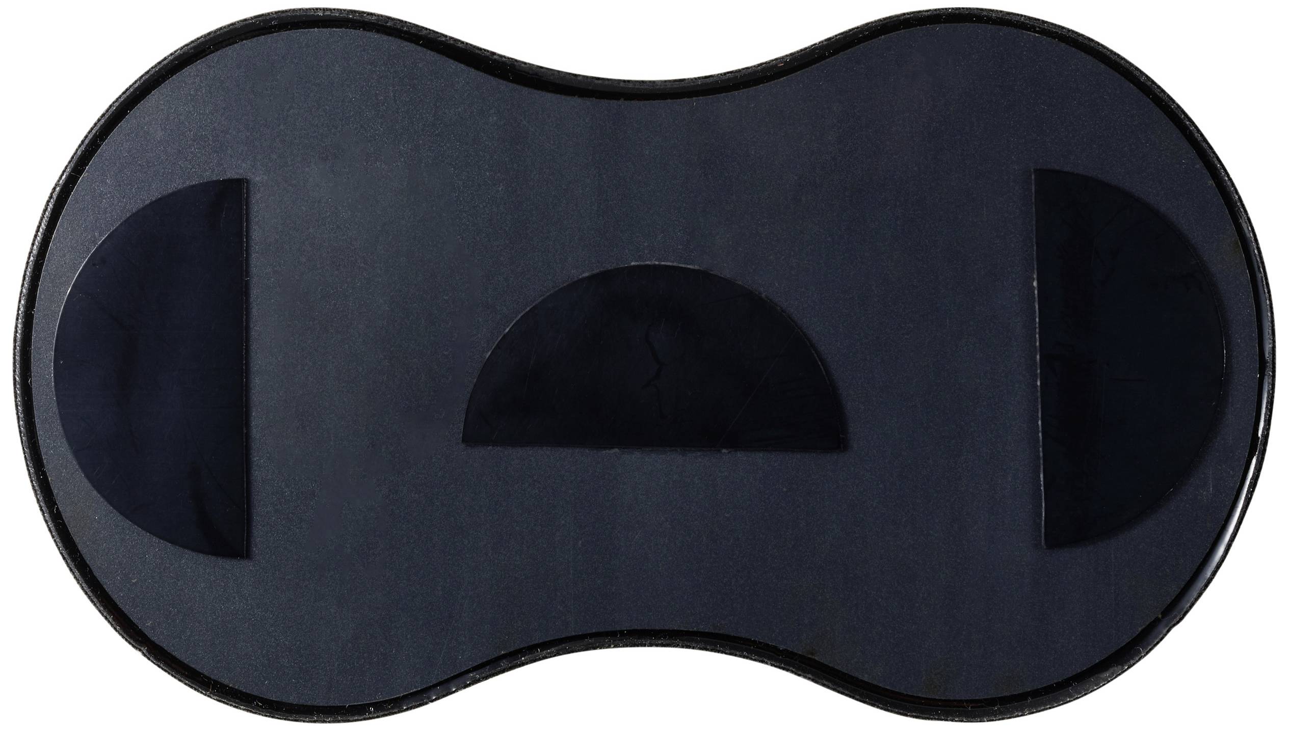 A black, kidney-shaped object with three darker areas: two rectangular ones at the ends and a semicircular one in the middle.