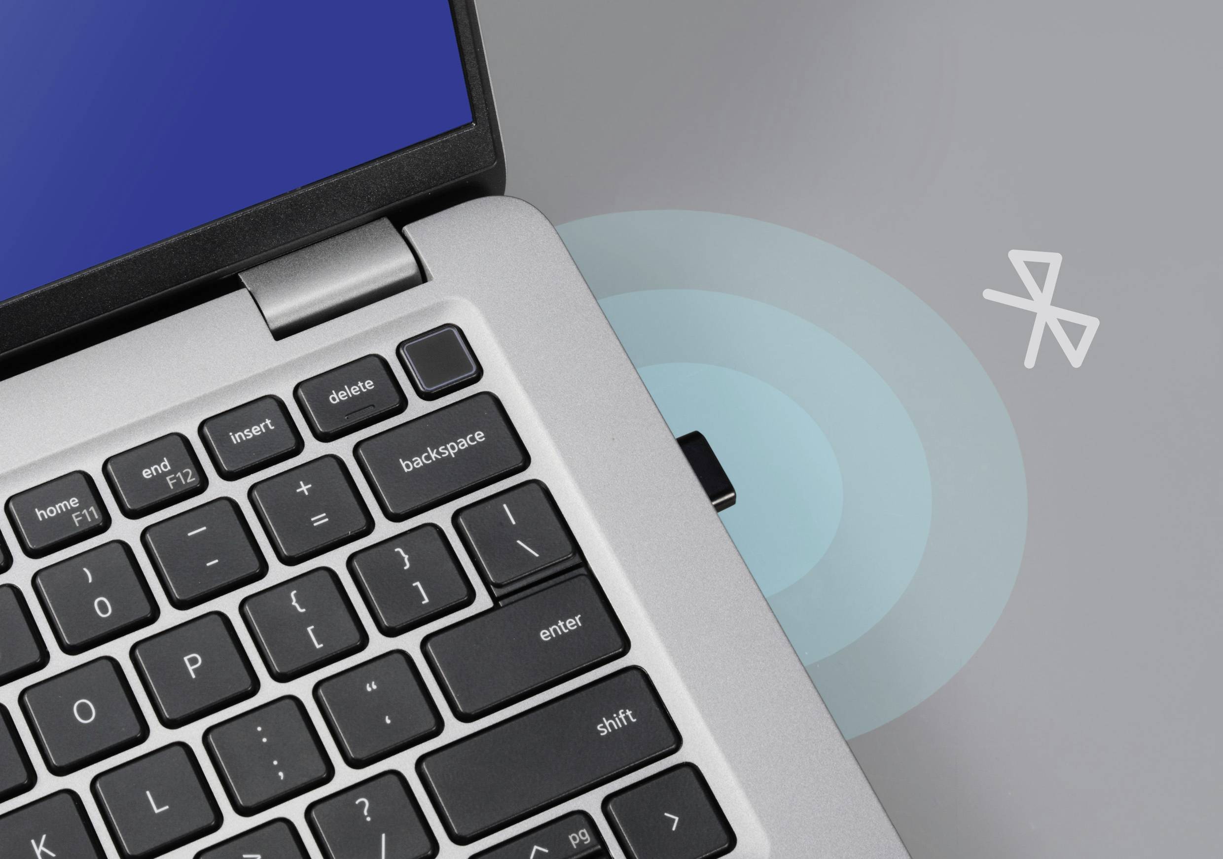 Laptop with Bluetooth symbol, showing wireless connection; focus on keyboard and activated Bluetooth module.