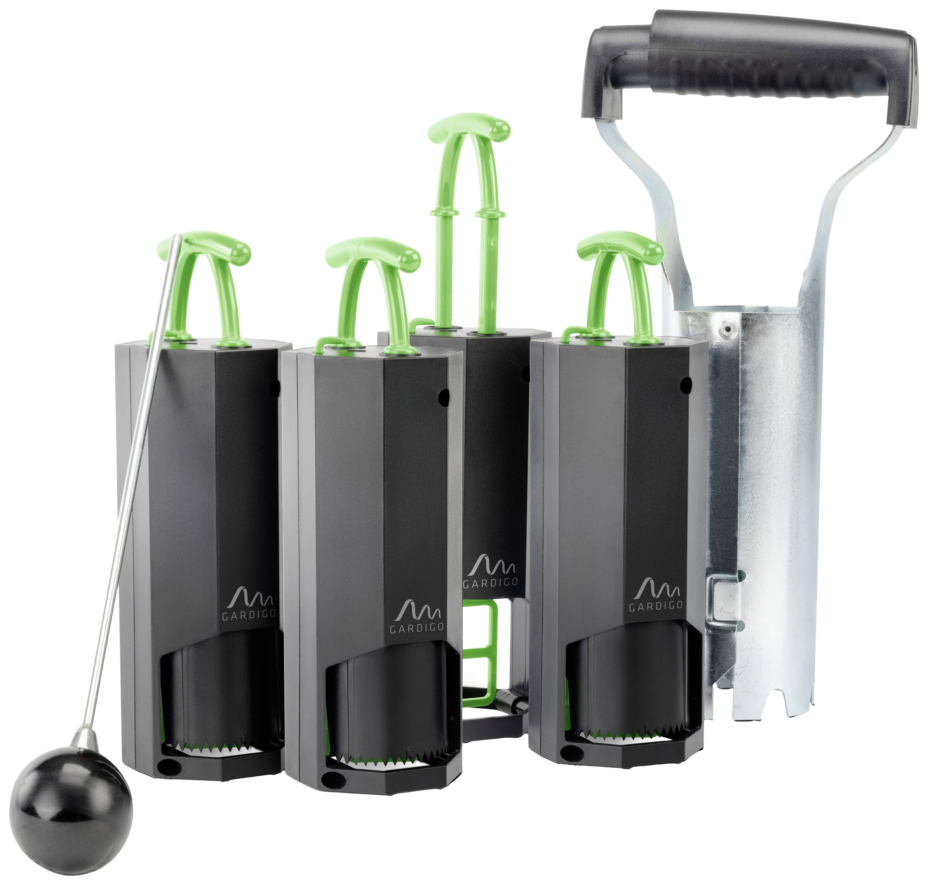 Three black devices with green levers stand side by side, with a metal holder with a black handle on the right. On the left, a black ball on a rod.