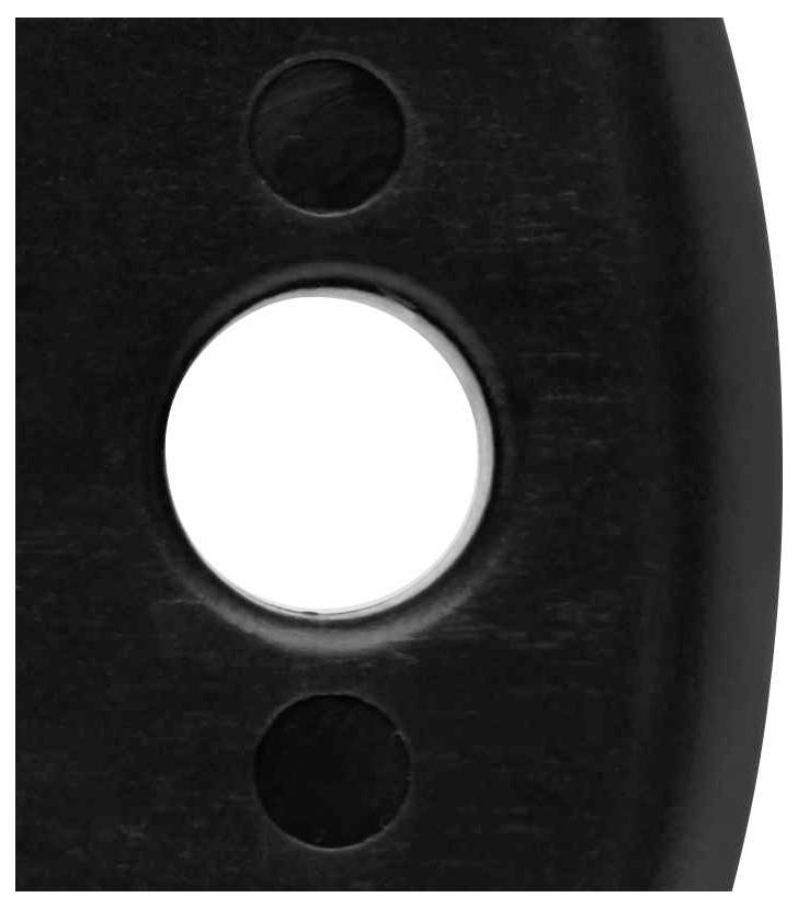 Three round holes in a black surface, one of them illuminated and centrally positioned.