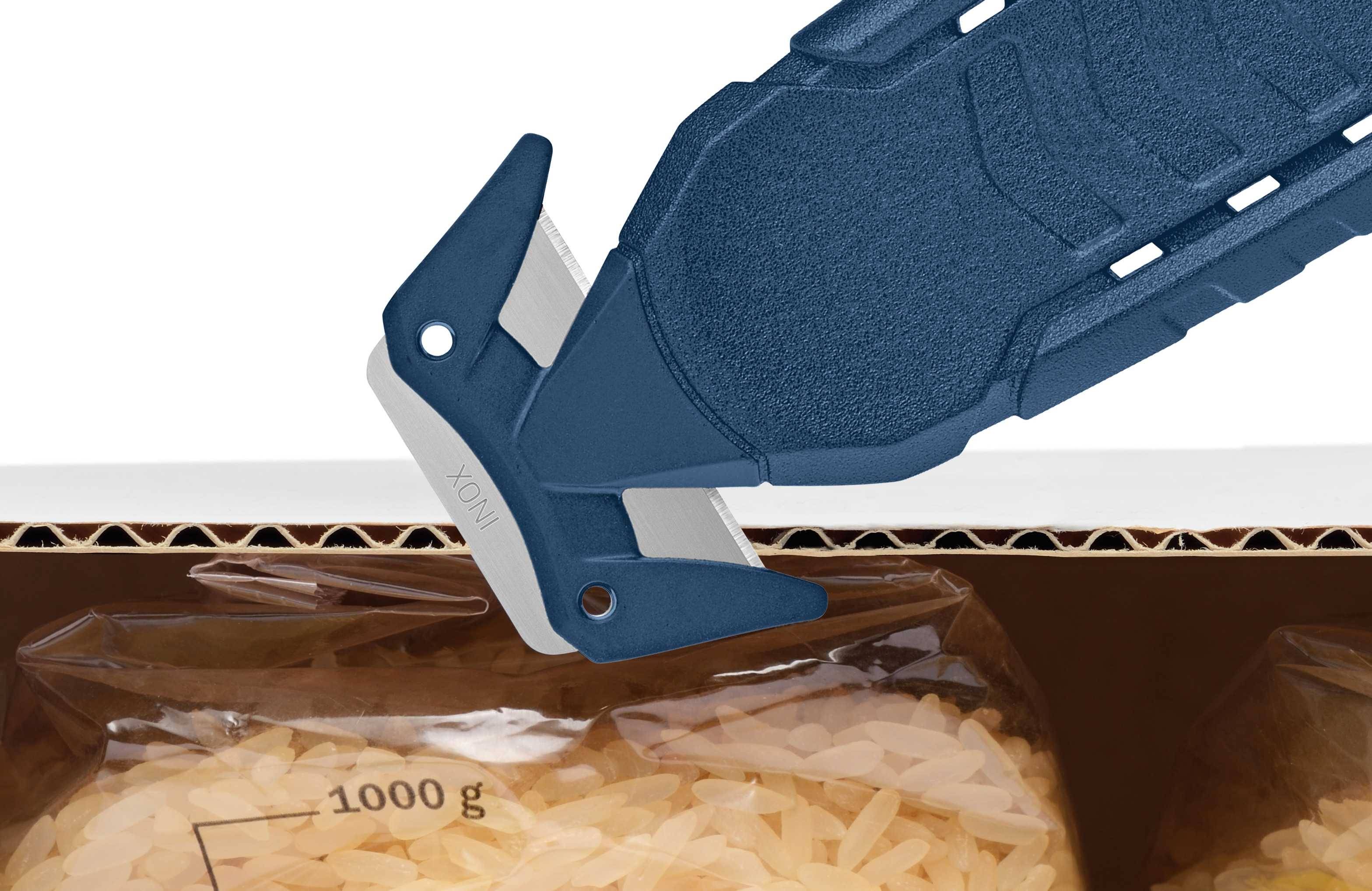 A blue safety knife carefully cuts a plastic bag of rice. The bag is located in a cardboard box.