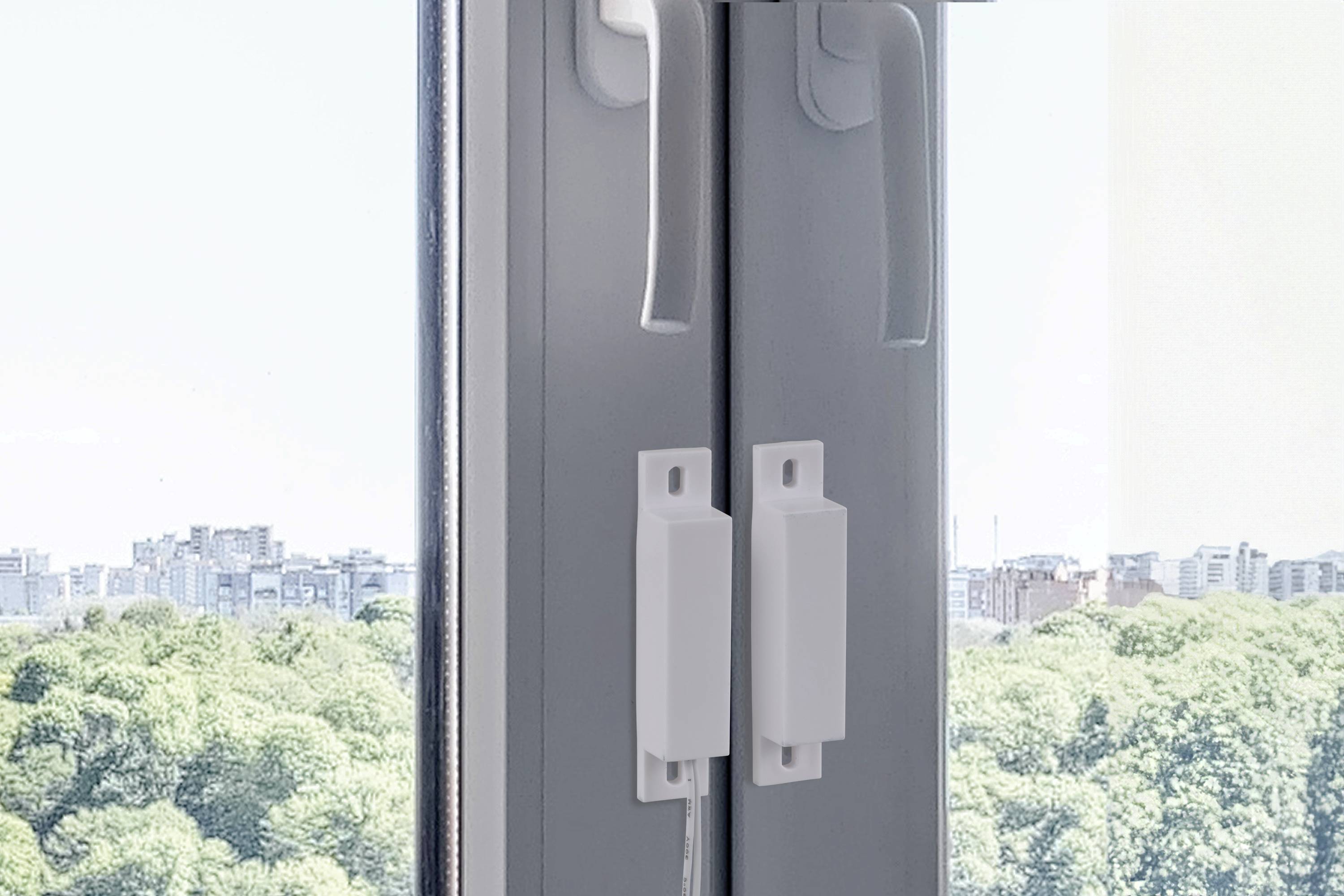 View of a closed window with a concealed handle mechanism, with trees and a distant city skyline in the background.