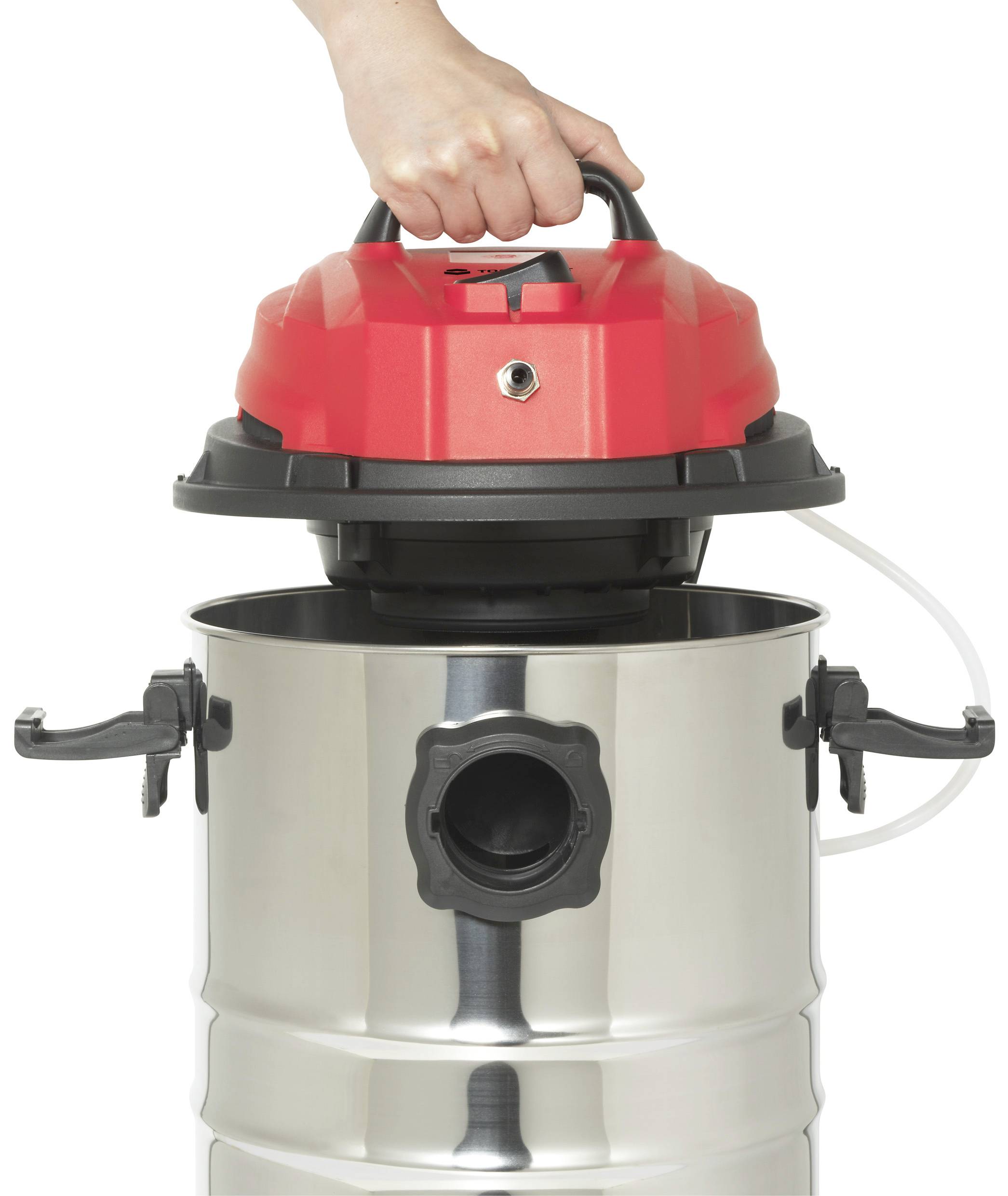A hand lifts the red lid of a silver industrial vacuum cleaner. The vacuum cleaner has side handles and a large hose connection at the front.