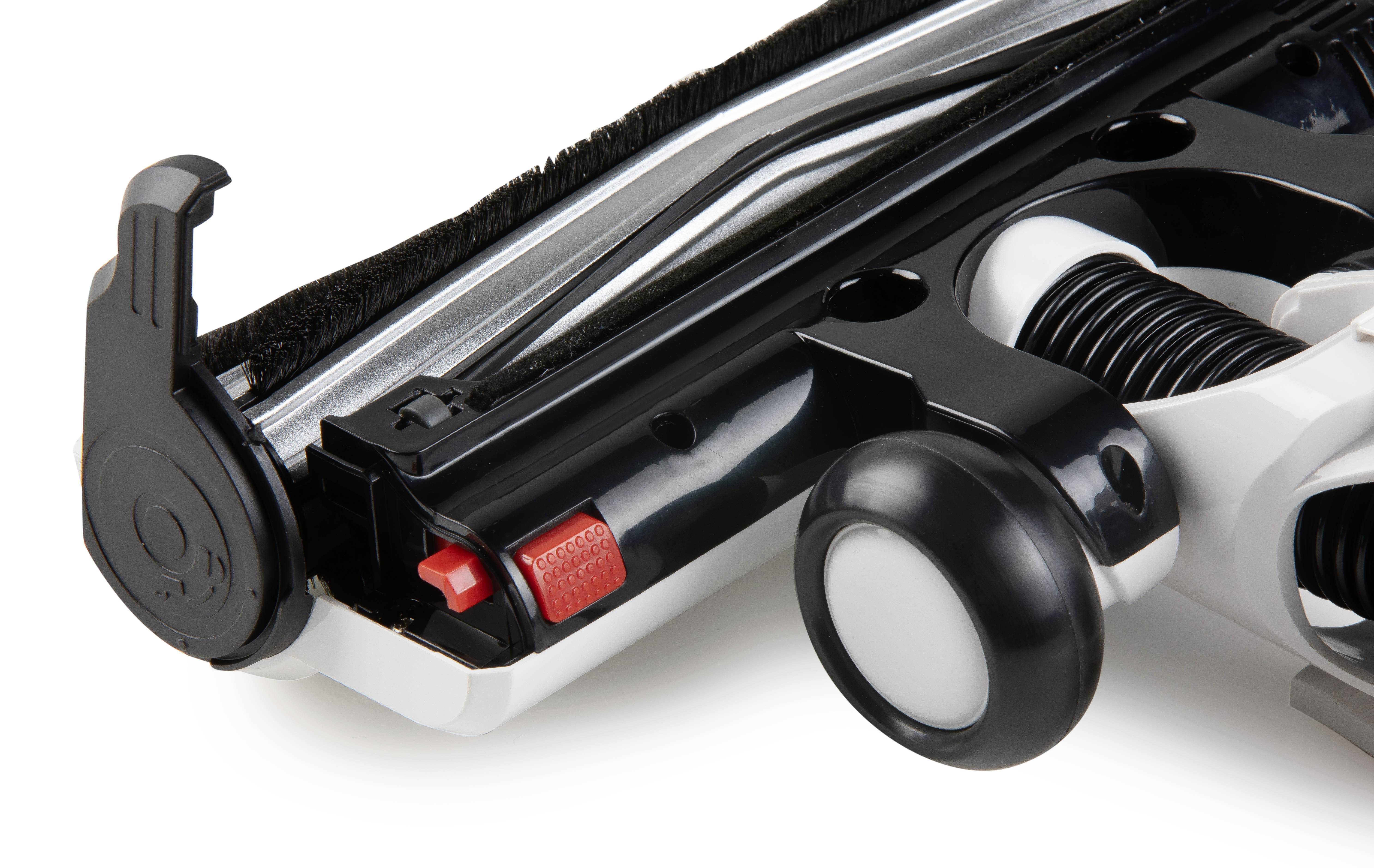 A close-up of a vacuum cleaner's black and white brush roller, with a red and black button and white wheels.