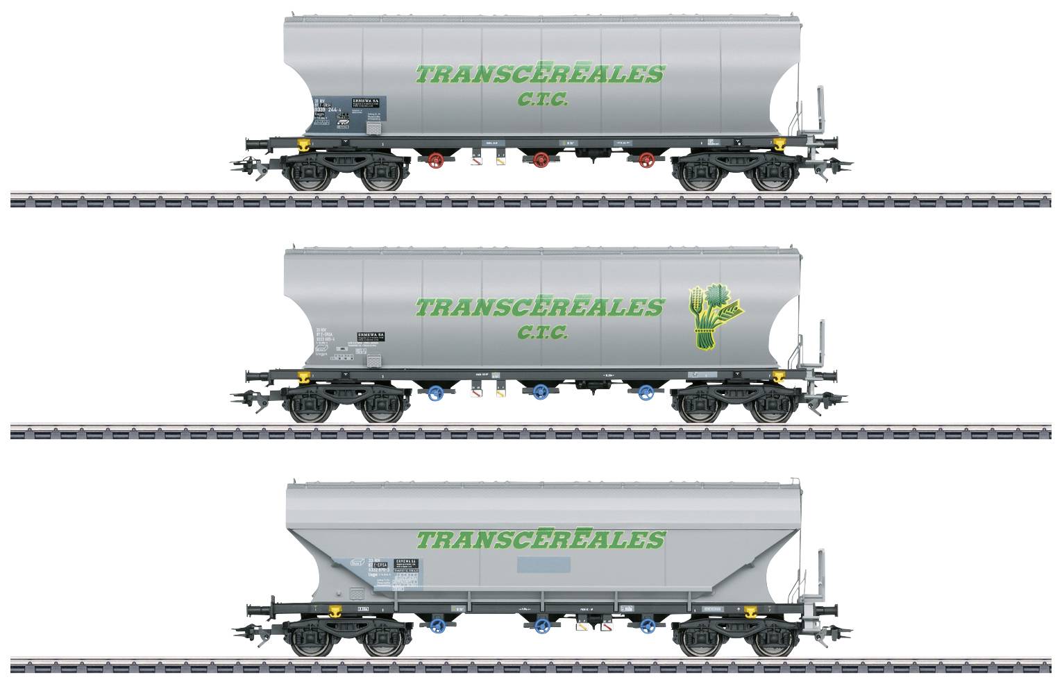 Three grey freight wagons with the inscription 'TRANSCÉRÉALES C.T.C.' on railway tracks. Each wagon has slight variations in its design.