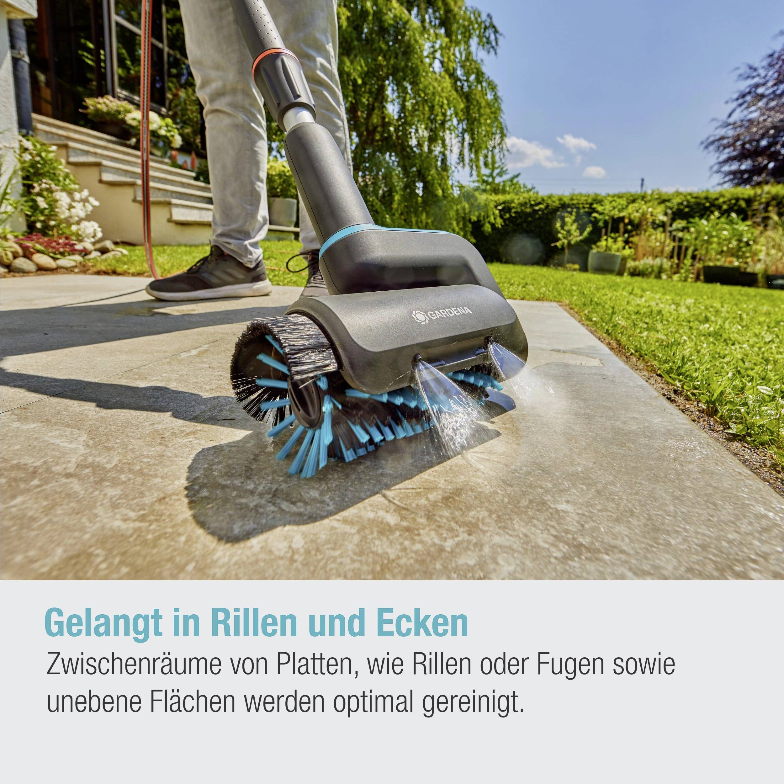 A device is cleaning joints on a terrace surface. Text: 'Reaches into grooves and corners'. Background shows plants and a sunny day.