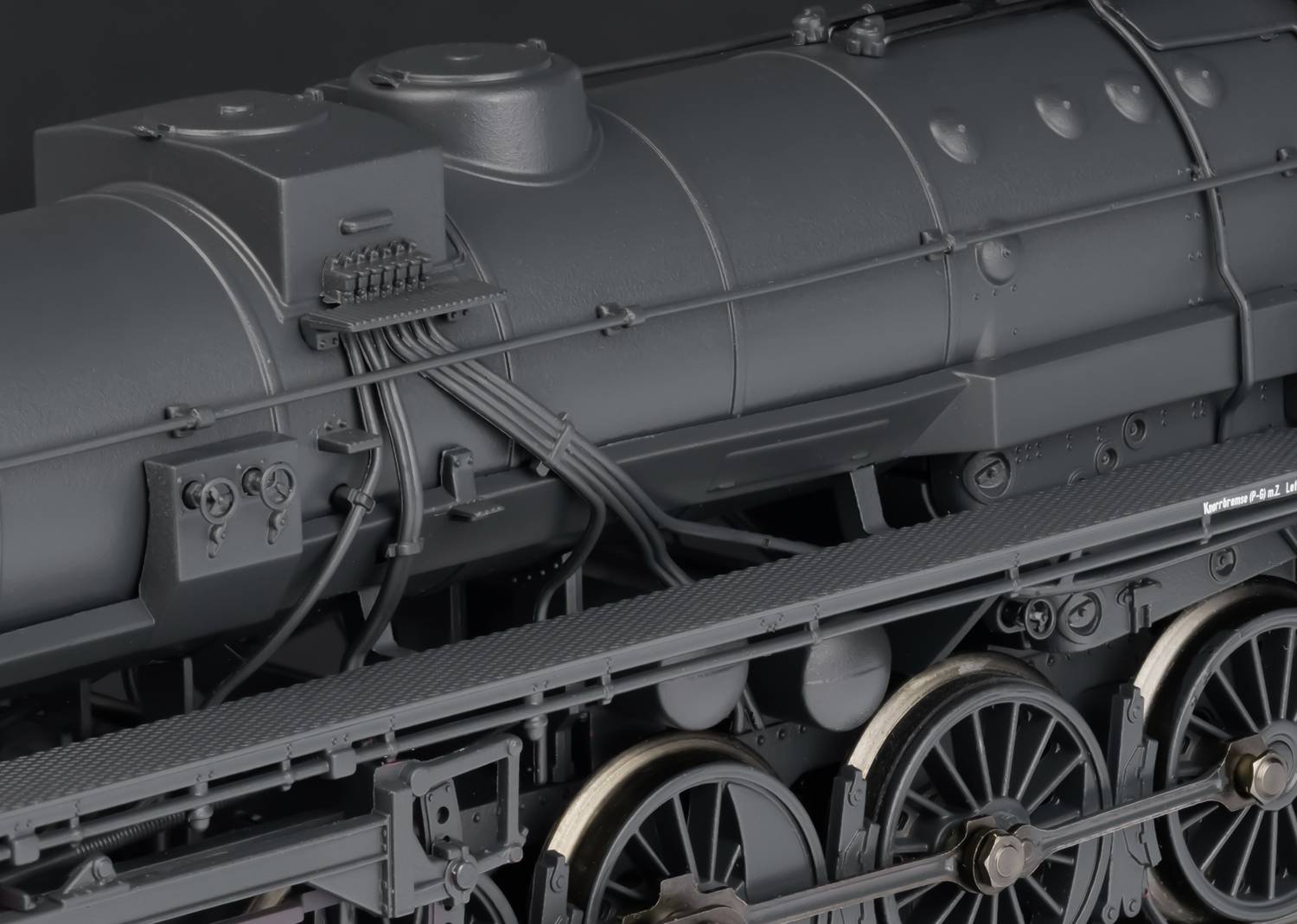 Close-up of a black steam locomotive model with boiler, with details of pipes and wheels visible.