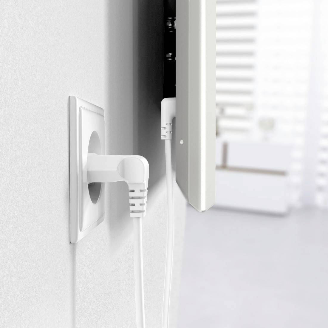 A white network cable is plugged into a socket on a white wall, while another cable is connected to a device.