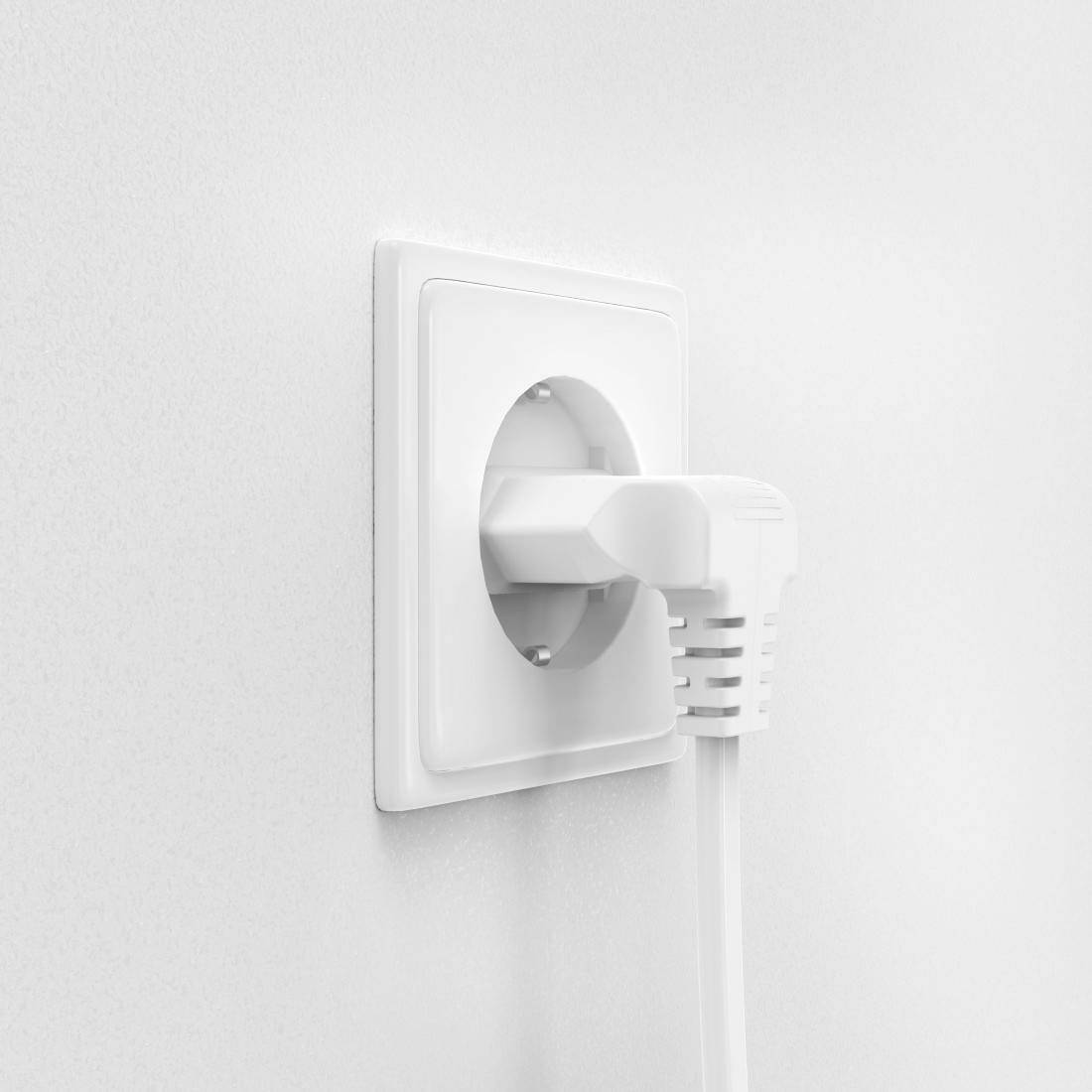 A white cable is plugged into a white socket on a white wall.