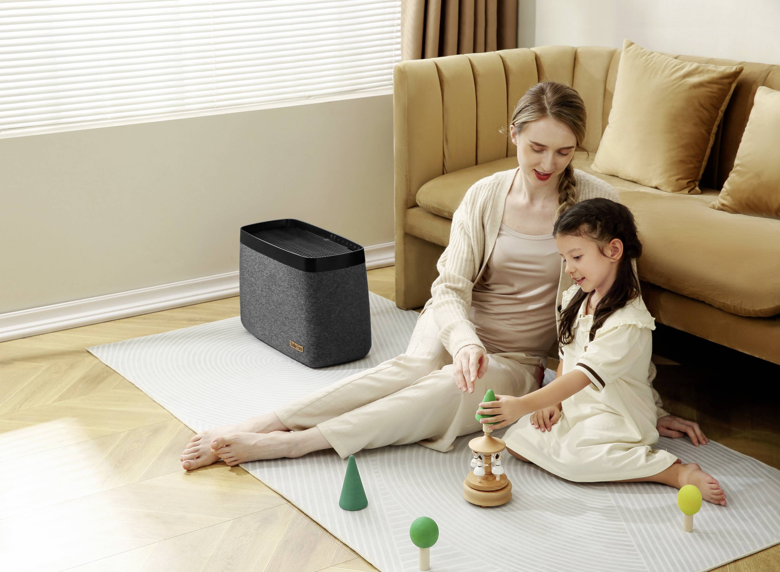 A woman is sitting on a carpet in the living room with a child, playing with wooden toys. A speaker is in the background.