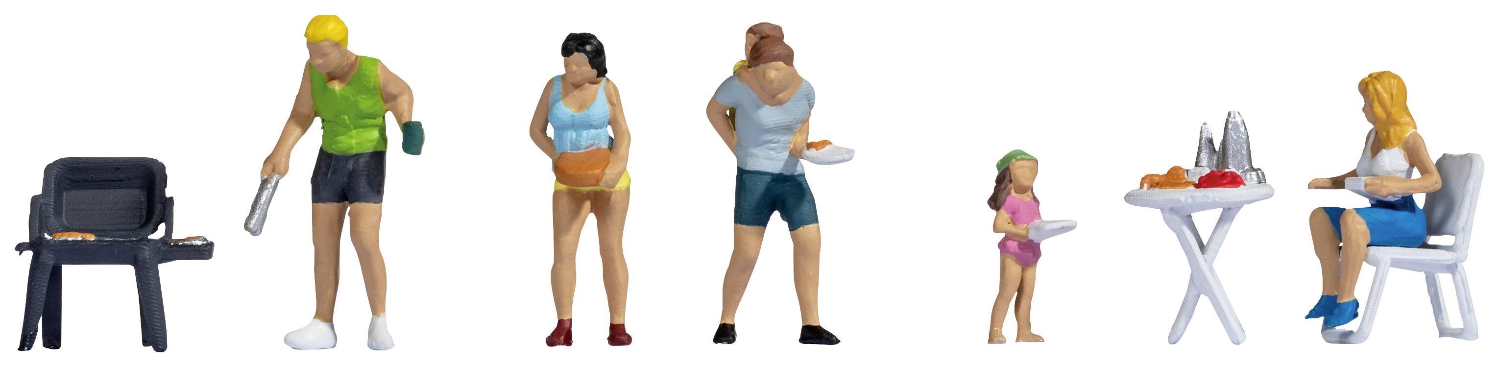 Miniature figurines of a family barbecuing. A man is grilling, a woman is holding a tray, a man with a plate, a child and a woman at the table.