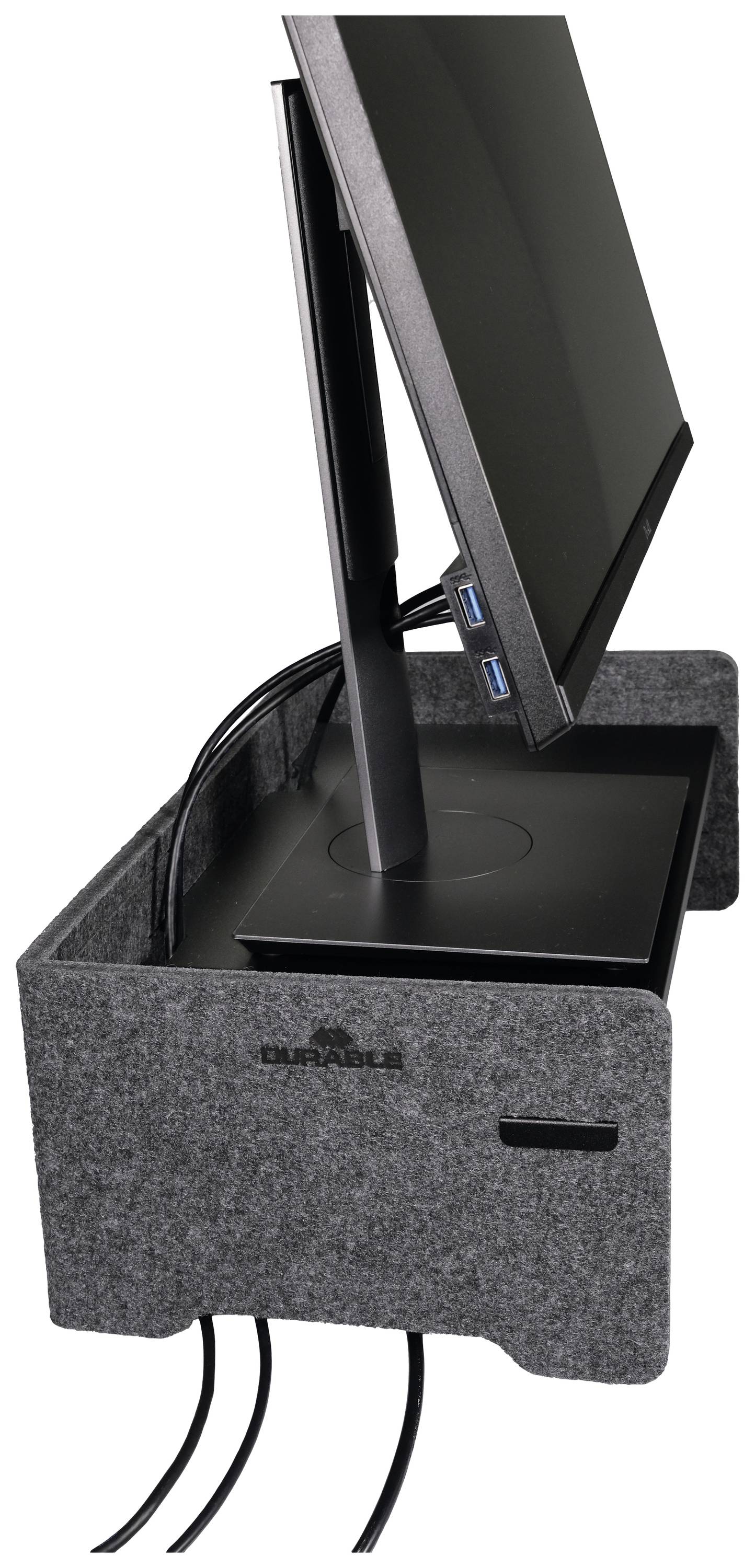 A monitor sits on a grey felt desk mat with cable management. Three cables are routed through the side opening.