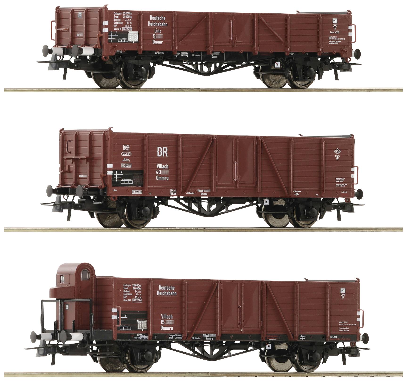 Three model railway carriages in rust-brown colour, with Deutsche Reichsbahn inscriptions, placed side by side on sections of track.