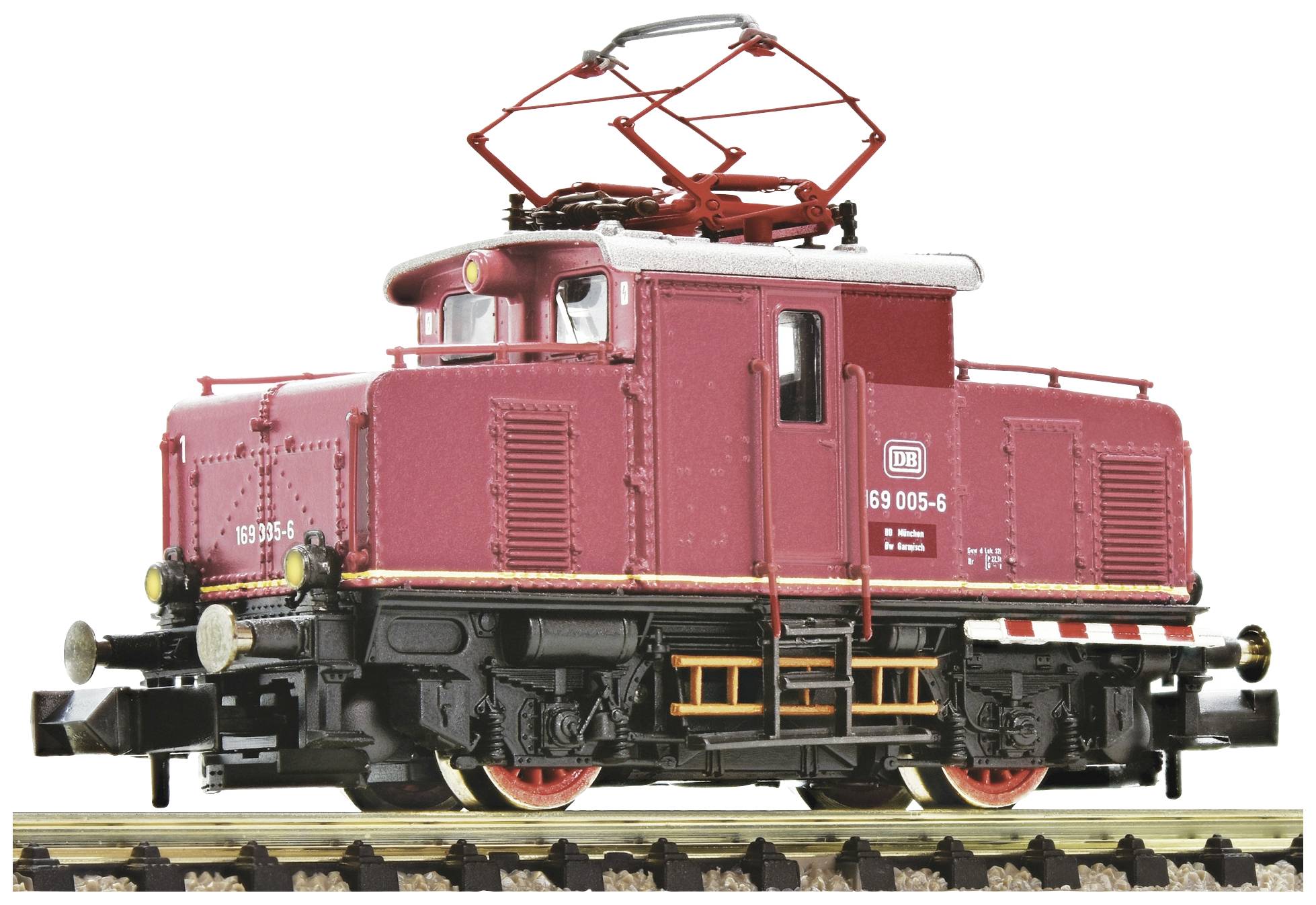 A red model locomotive of the Deutsche Bahn stands on railway tracks. It has a visible DB logo and is intricately designed.