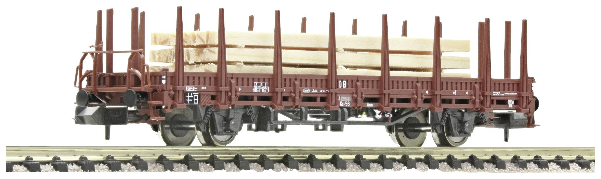 A goods wagon is transporting timber logs on railway tracks, secured by vertical metal stanchions.