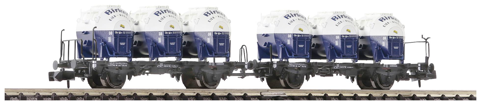 A goods train wagon is transporting several blue and white tank containers. They are labelled 'Shibu' and are positioned on railway tracks.
