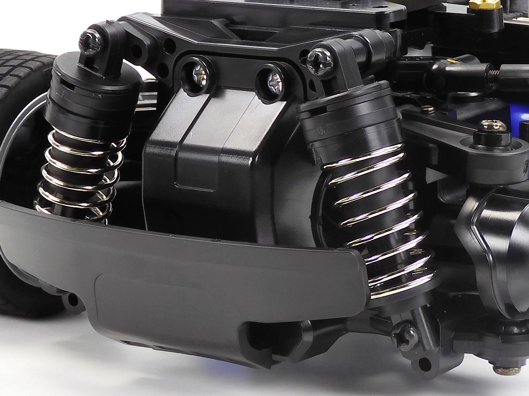 Close-up of a model car suspension system with shock absorbers and springs. Demonstrates technical details of the construction.