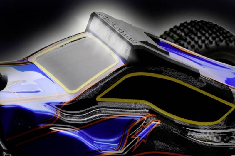 Close-up of a remote-controlled model car with a blue and black bodywork, striking yellow lines, and large tyres.