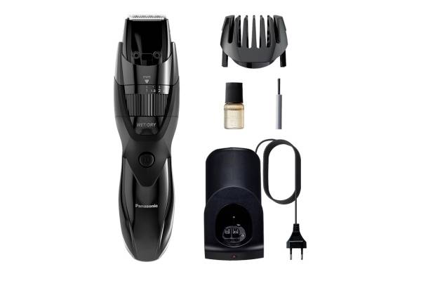 A black electric hair clipper with charger, beard comb attachment, oil bottle, and cleaning brush.