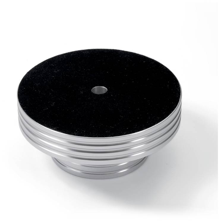 A cylindrical, silver object with black stripes and a small opening at the top, positioned on a white surface.