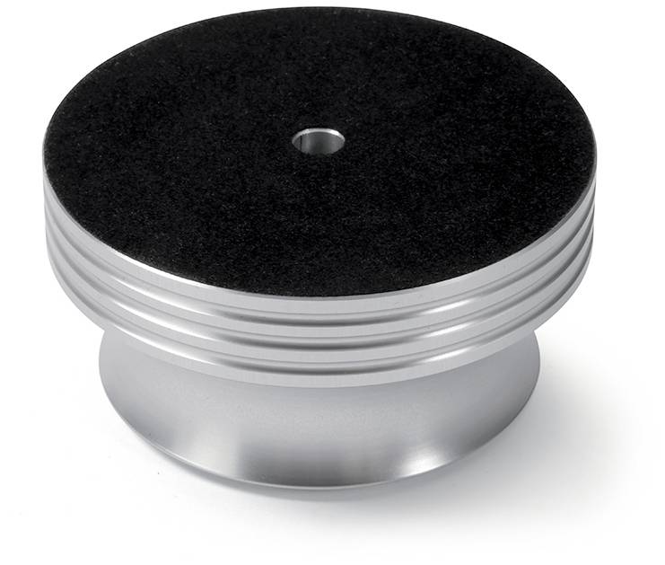 Round, silver metal figurine with a dark top surface. Has grooves on the side and a central hole at the top.