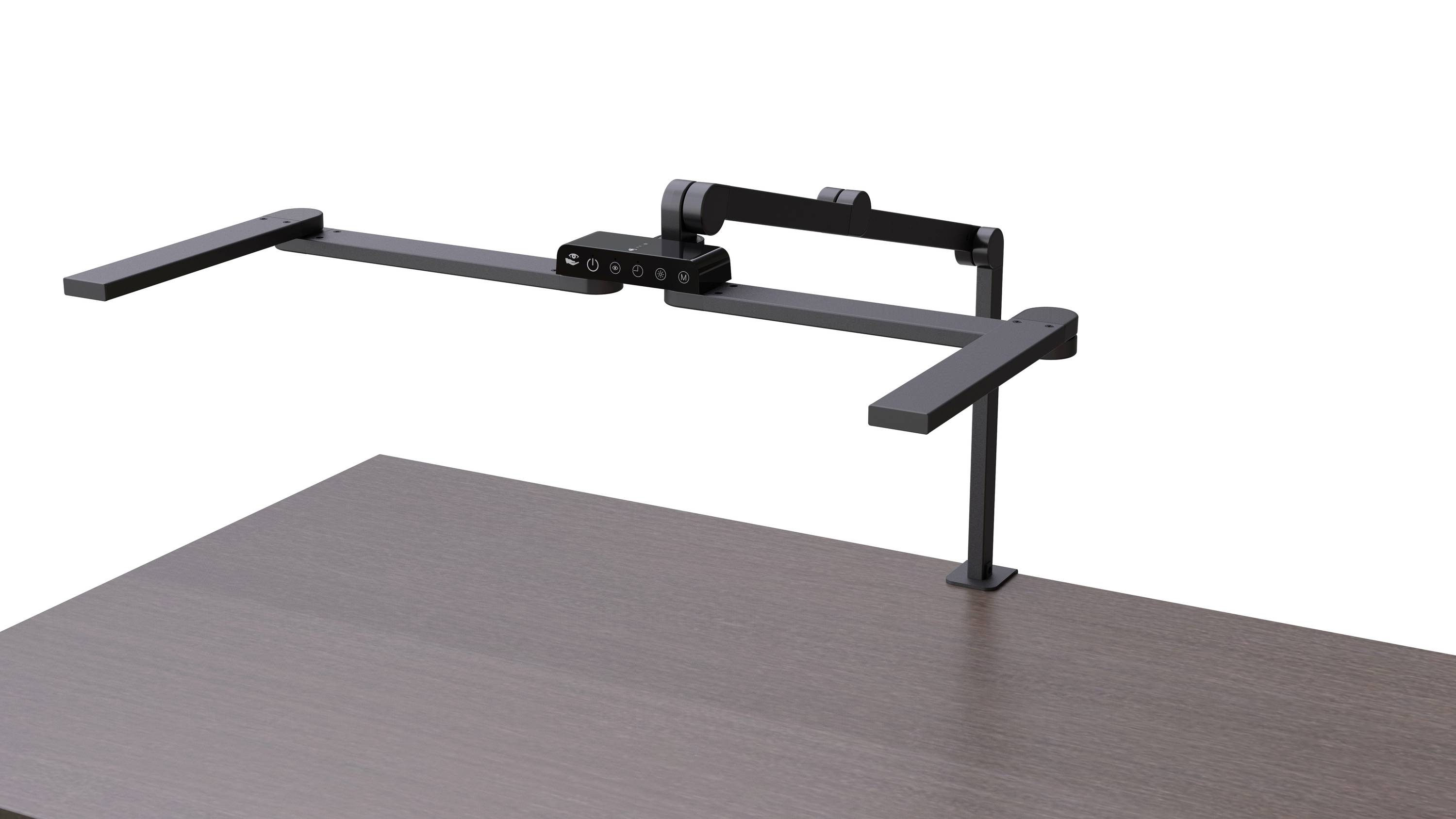 A dark grey monitor arm is attached to the back of a wooden desk. The arm has a flexible adjustment option.