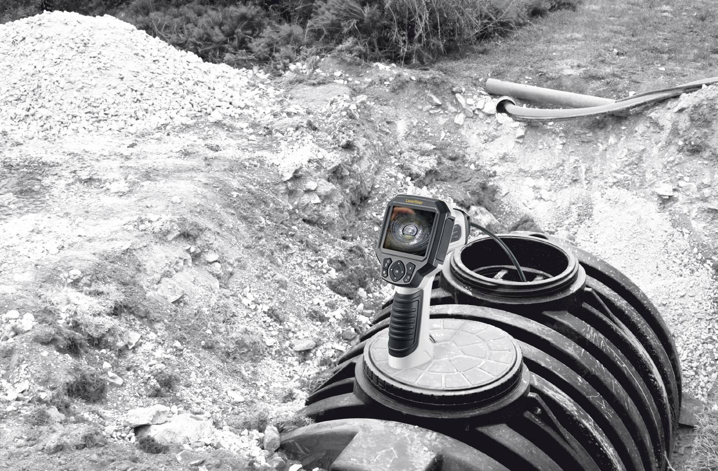 A camera is examining a sewage system underground. The device is positioned on an open manhole to inspect the internal structure.