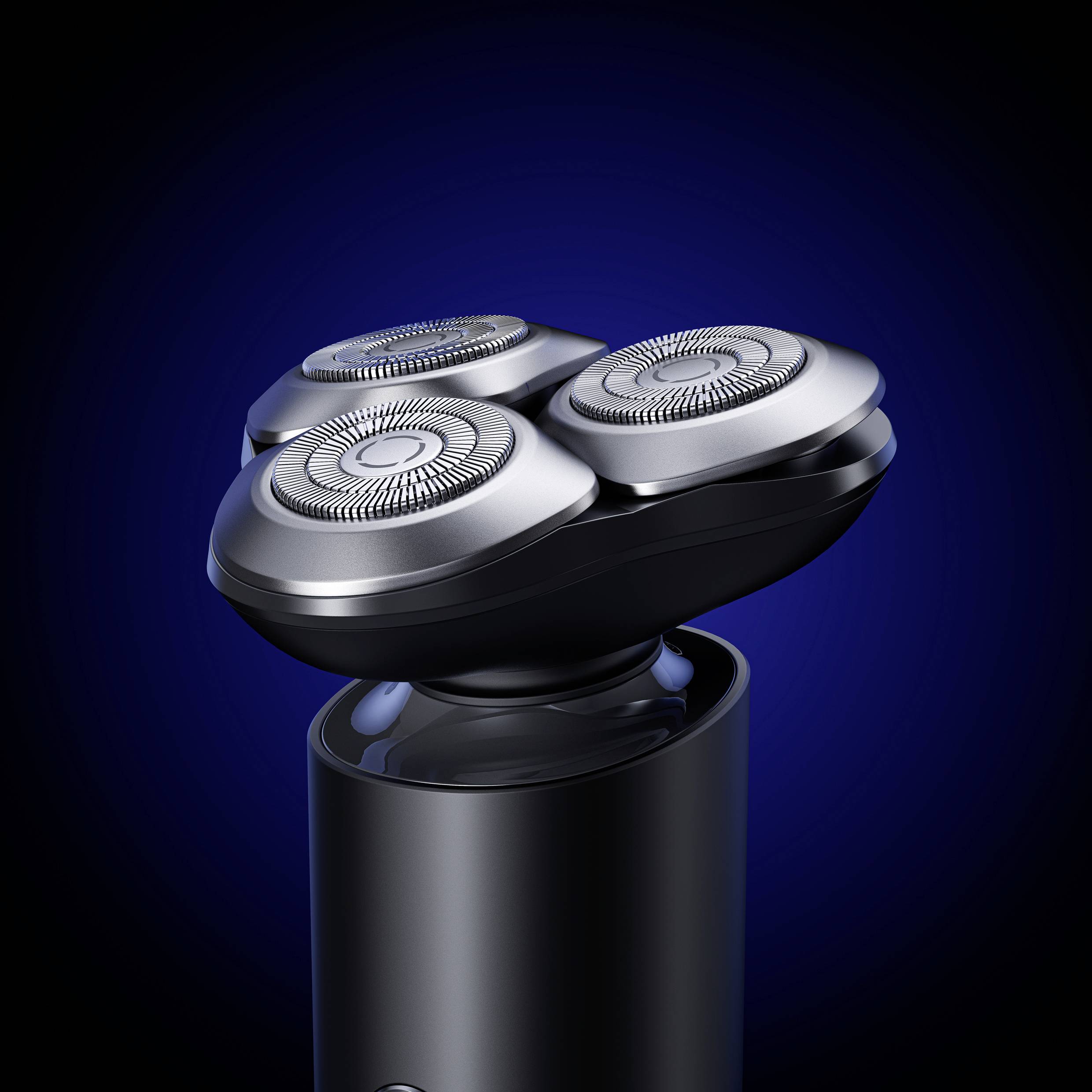 Electric shaver with three round cutting heads against a dark background, highlighted by light reflection.