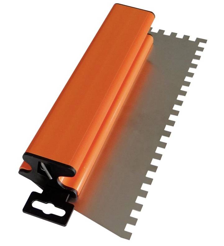 An orange tile trowel with a serrated metal edge, used for spreading adhesive when laying tiles.