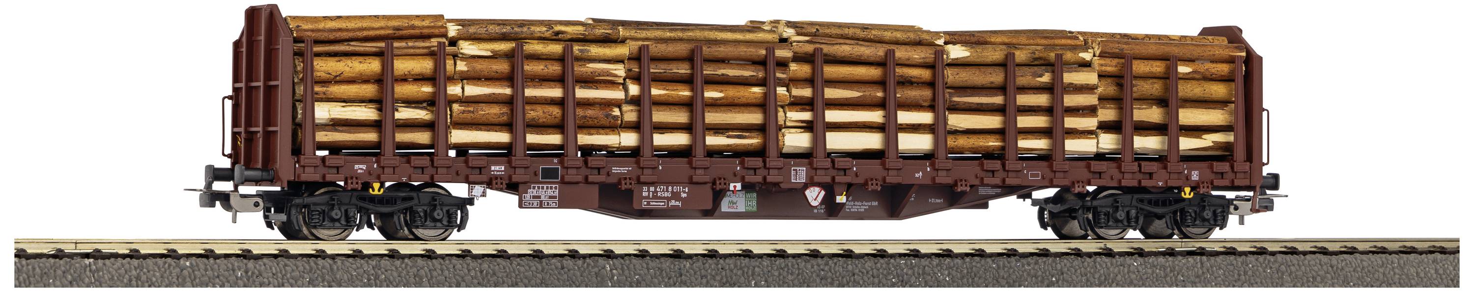 A goods train wagon fully laden with timber logs travels along railway tracks.