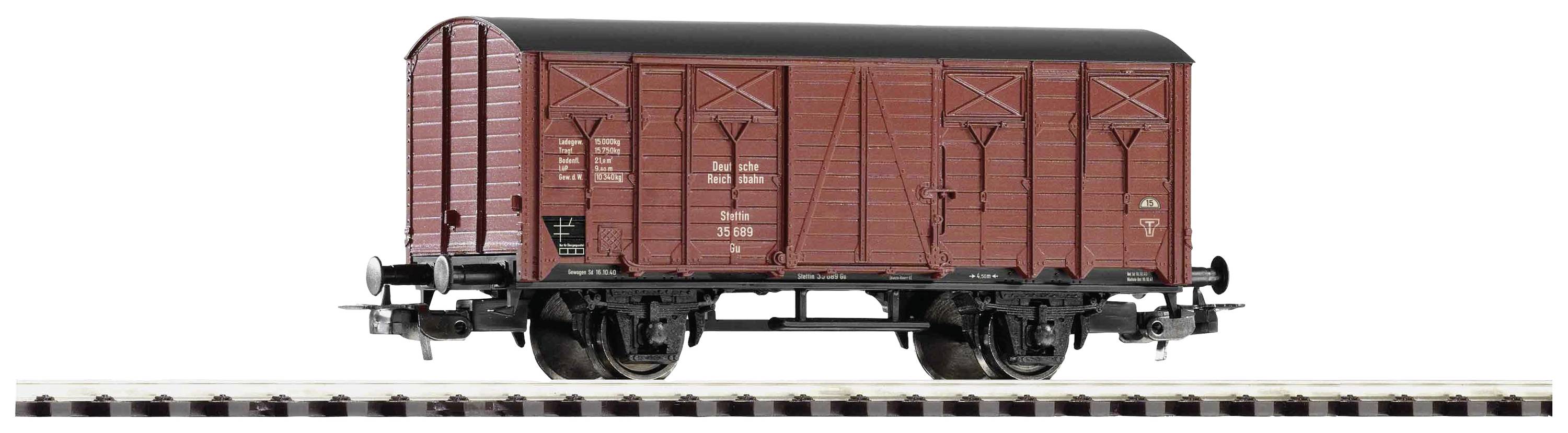 Covered goods wagon on a railway track, with a brown wood-effect finish, featuring black details and metal turntables.