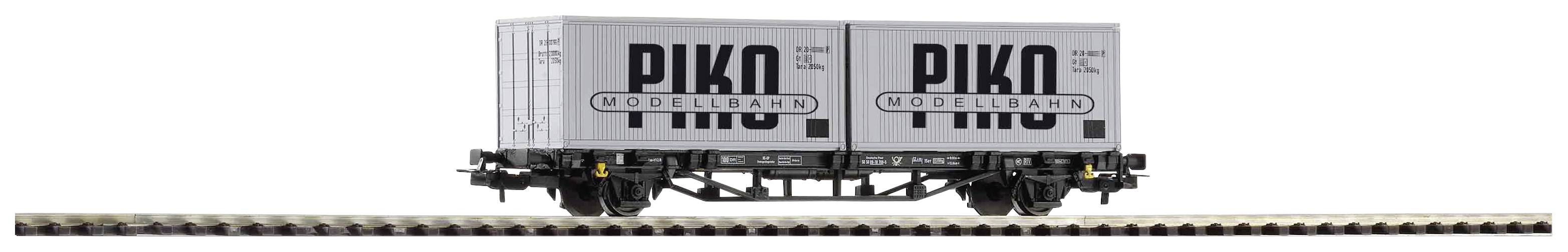A model railway goods wagon with two white containers, printed with 'PIKO' and 'MODELLBAHN', is travelling on tracks.