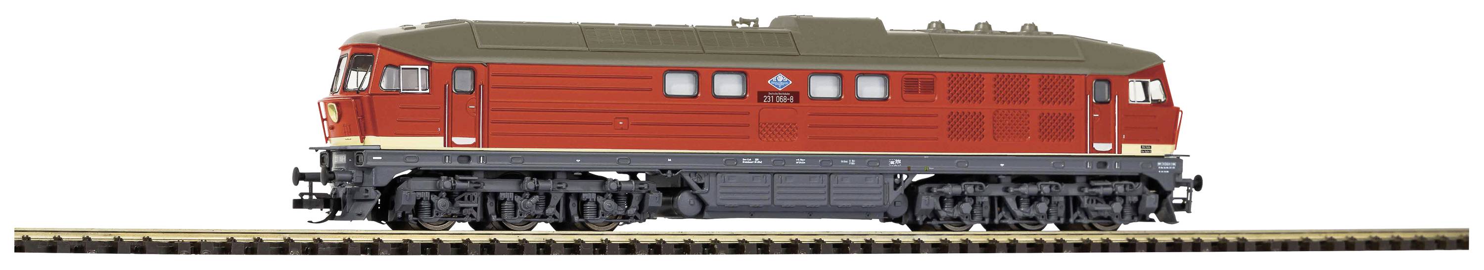 A red model railway locomotive stands on a track. It has a robust design with detailed wheels and distinctive ventilation grilles.