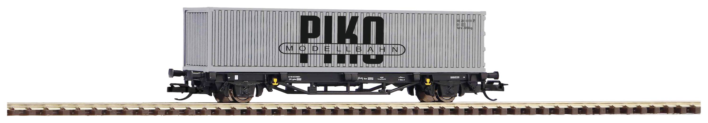 Grey-grey goods wagon with 'PIKO' inscription on a short section of track.