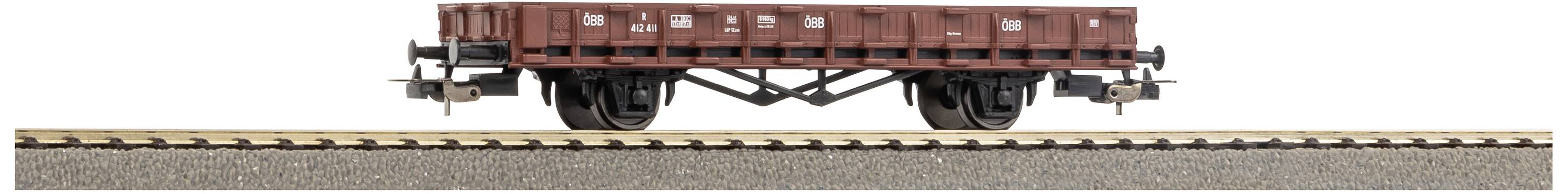 An empty, rust-coloured goods wagon stands on a section of railway tracks. The background is neutral and does not distract.
