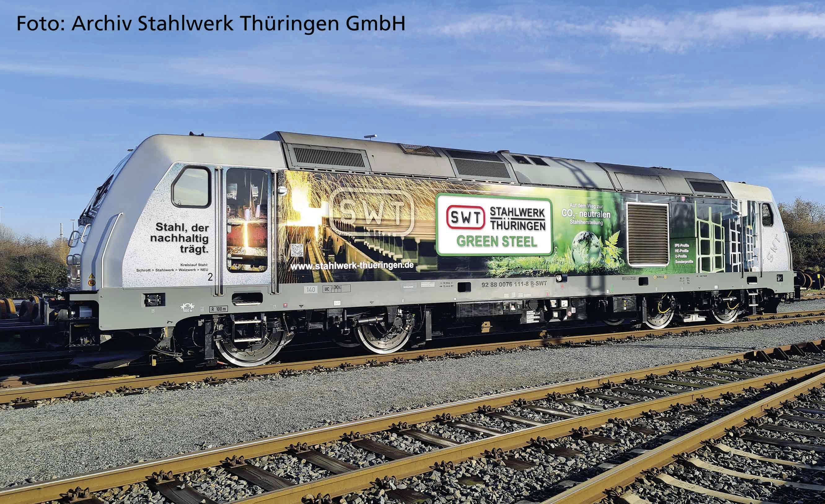 A freight train with the inscription 'Steel that sustainably supports' and 'SWT Stahlwerk Thüringen Green Steel' on the side.