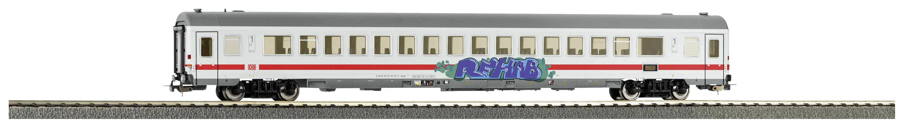 A model of a German intercity passenger carriage on a piece of track, with graffiti on its side.