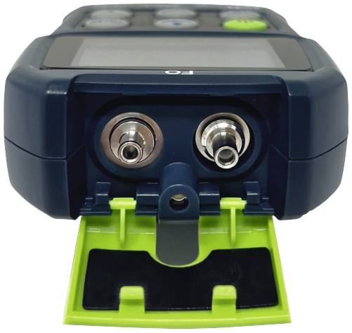 A digital measuring device with two socket connectors and an open green cover, likely used for measuring electrical signals.