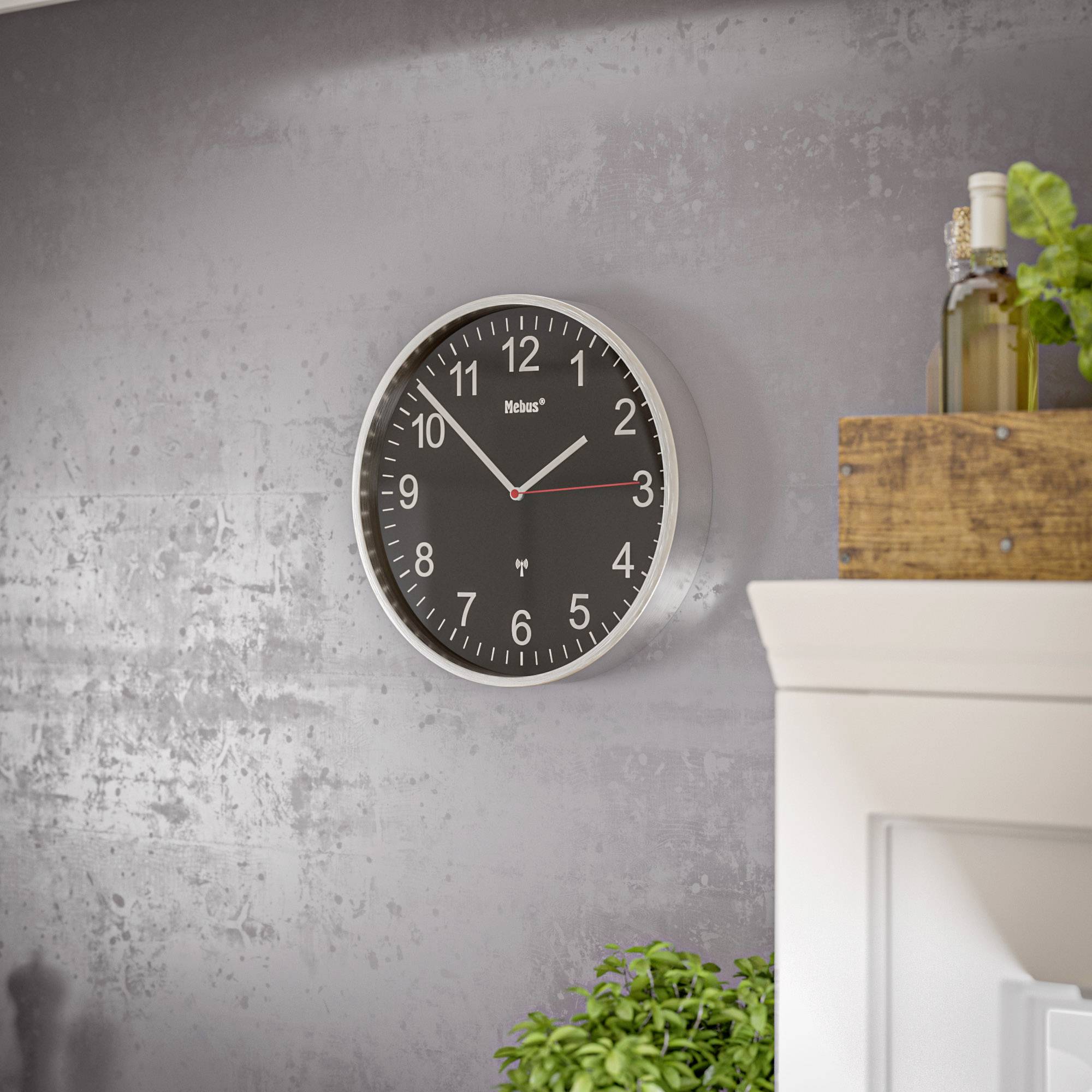 Black wall clock with white numerals shows 10:10, hanging on a grey wall. Next to it are a plant and a wooden shelf.
