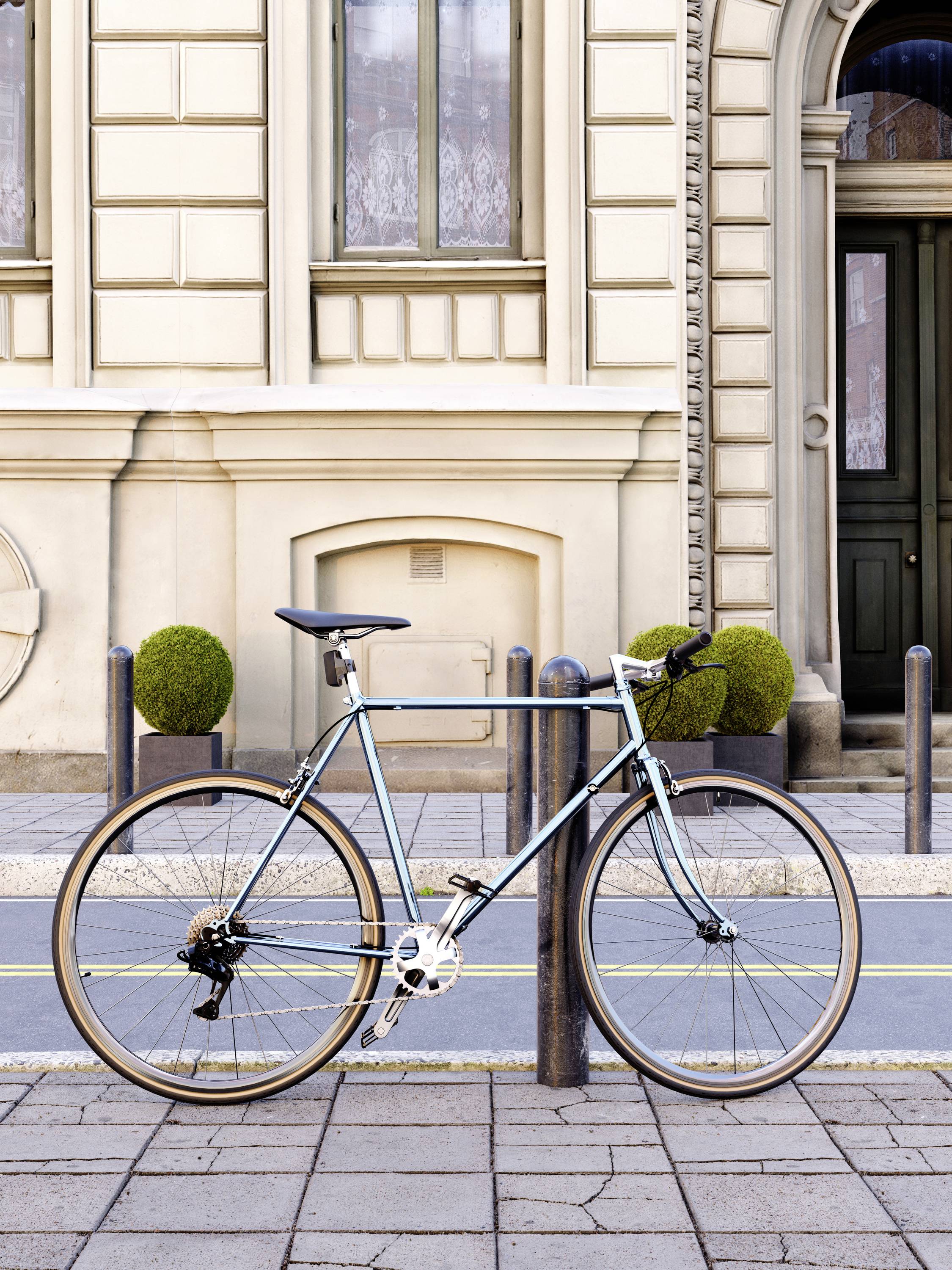 A light blue bicycle is leaning against a bollard in front of a historic building with large windows and decorative plants.