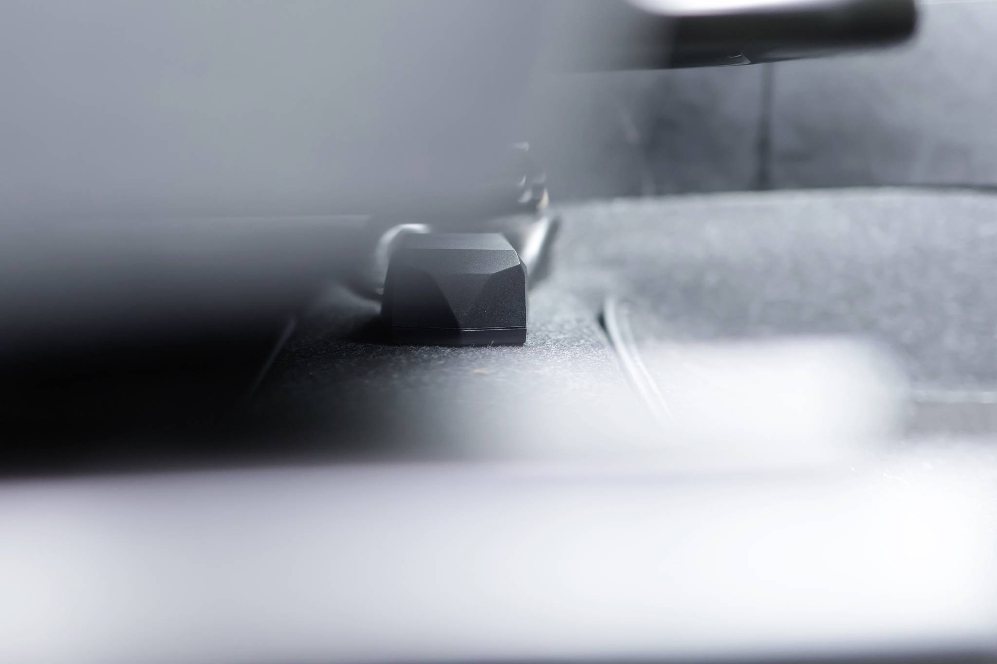 A close-up of a component inside a vehicle, possibly a suspension part. Blurred background, with the main object in focus.