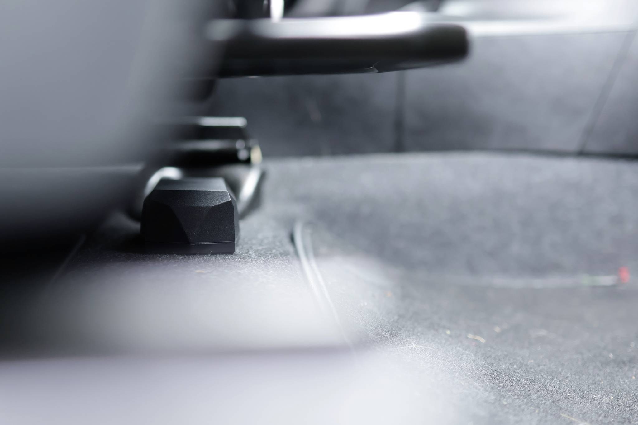 Blurred interior of a car, focusing on the floor area between the front and rear seats.