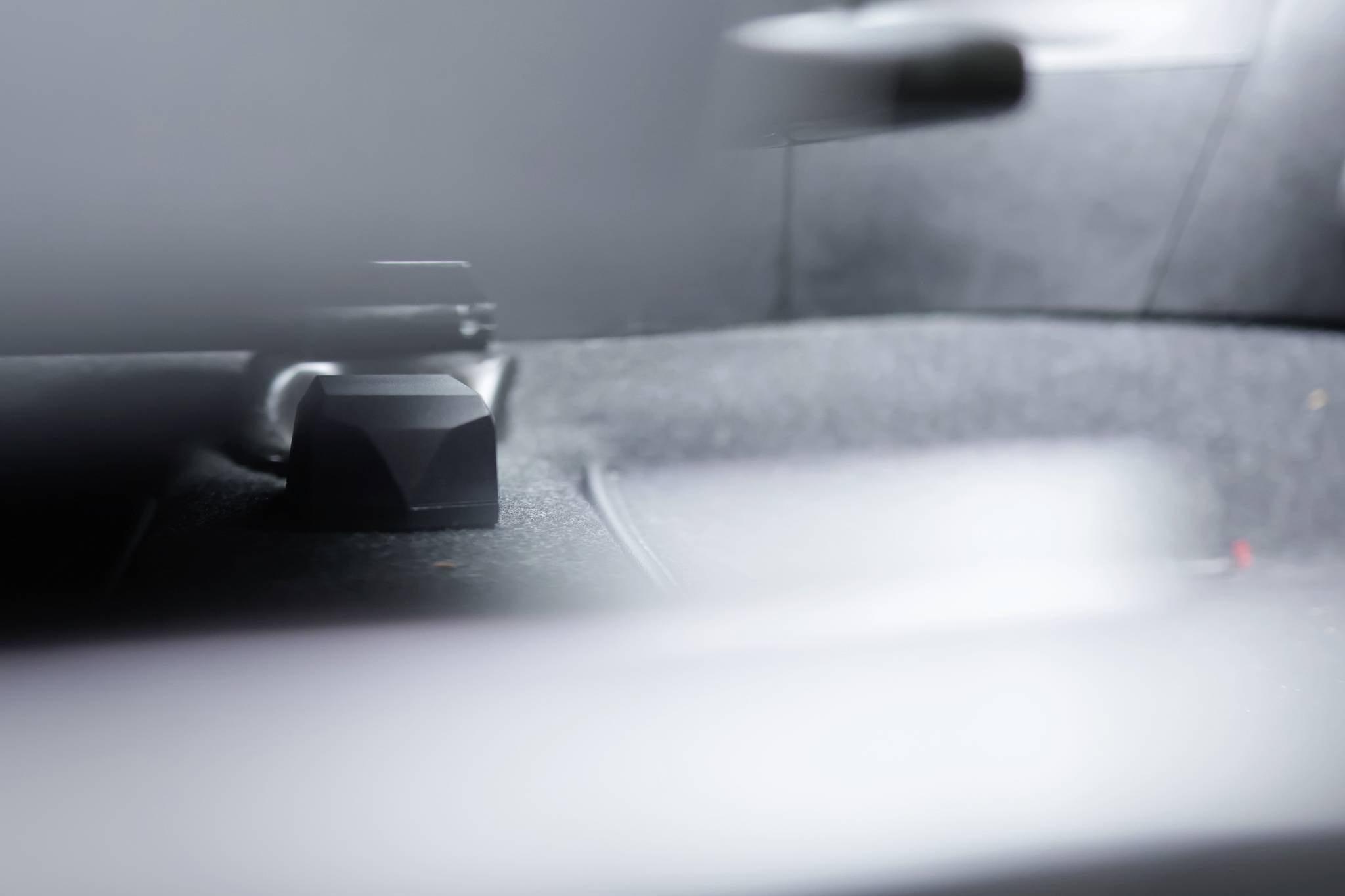 Blurry image of a car interior, focused on the floor and part of a seat.Note: The translation is already in British English, so no changes were necessary.