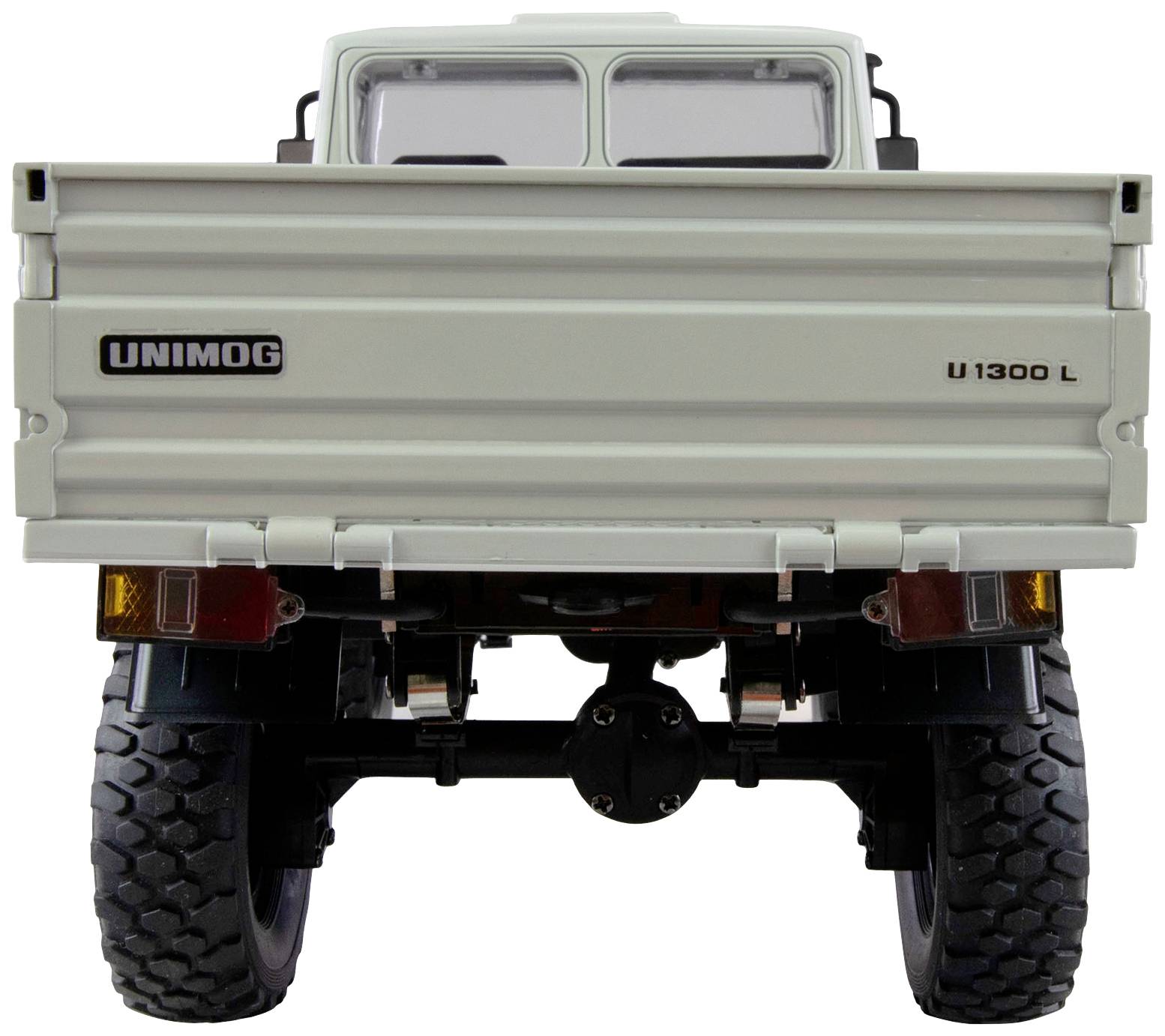 Rear view of a white Unimog U1300 L model with open load compartment flaps, robust tyres, and clear vehicle details.