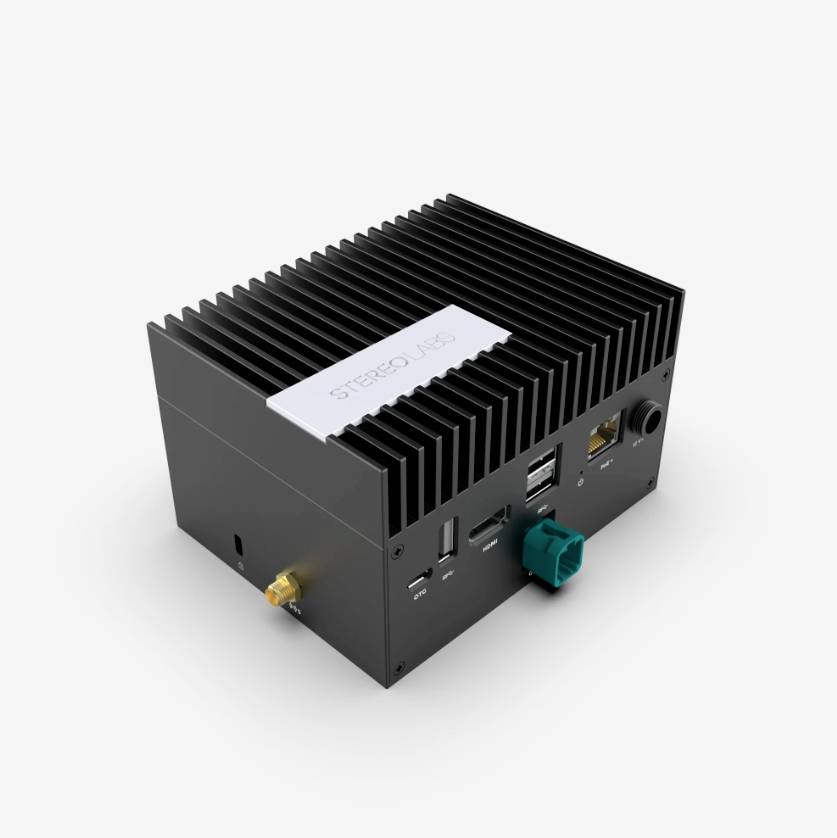 A small, black computer with heat sinks and multiple ports, including USB and Ethernet connections.