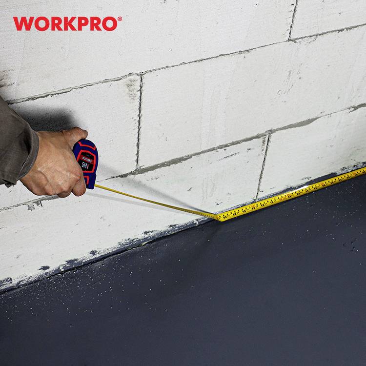 A person is measuring the length on a grey concrete wall using a yellow tape measure. 'WORKPRO' is written in the top left corner.
